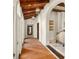 Hallway with arched entryways, dark hardwood doors, and wood beamed ceiling at 11324 Bridge House Rd, Windermere, FL 34786