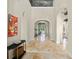 Bright hallway with arched ceilings, stone floors and statement art at 11324 Bridge House Rd, Windermere, FL 34786