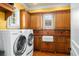 Spacious laundry room with sink, decorative backsplash, custom cabinetry and natural lighting at 11324 Bridge House Rd, Windermere, FL 34786