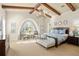 Spacious main bedroom with beamed ceiling, arched window, seating area, and chandelier at 11324 Bridge House Rd, Windermere, FL 34786