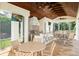 Outdoor kitchen with stainless grill, blue patterned backsplash, and a wooden beamed ceiling at 11324 Bridge House Rd, Windermere, FL 34786