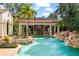 Beautiful outdoor pool and patio area with stone waterfall, hot tub, and covered dining at 11324 Bridge House Rd, Windermere, FL 34786