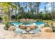 Gorgeous backyard pool area with a rock waterfall feature, lush landscaping, and a serene atmosphere at 11324 Bridge House Rd, Windermere, FL 34786