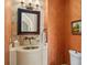 Charming powder room features mosaic sink, custom mirror and artistic painting at 11324 Bridge House Rd, Windermere, FL 34786