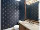 Elegant powder room featuring patterned wallpaper, marble countertop, and decorative lighting at 11324 Bridge House Rd, Windermere, FL 34786