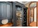 Custom wine storage and cooler with built in shelving and cabinetry, next to wet bar at 11324 Bridge House Rd, Windermere, FL 34786