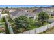 Aerial view of a private backyard with a white fence, lush trees, and well-maintained lawn at 123 Vitoria Rd, Davenport, FL 33837