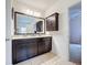 Bathroom with a double sink vanity, dark wood cabinets, and large mirror at 123 Vitoria Rd, Davenport, FL 33837