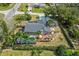 Aerial view of a home's backyard featuring a screened pool, a deck, and well-maintained landscaping at 12442 Sunshine Dr, Clermont, FL 34711