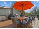 Outdoor dining on a spacious deck under a large orange umbrella and outdoor grill setup is perfect for entertaining guests at 12442 Sunshine Dr, Clermont, FL 34711