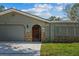 Charming single-story home features stone accents, a well-manicured lawn, and an attached two-car garage at 12442 Sunshine Dr, Clermont, FL 34711