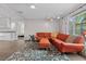 Bright living room showcasing orange leather seating, wood floors, and natural light from a window at 12442 Sunshine Dr, Clermont, FL 34711