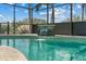 Screened in pool with waterfall feature under a blue sky at 12442 Sunshine Dr, Clermont, FL 34711