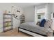 Well-lit bedroom featuring a striped bedspread, decorative shelves, and a window view at 1251 Big Bass Dr, Ormond Beach, FL 32174