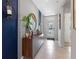 Bright foyer featuring beige tile flooring, decorative mirror, cabinet, and a glass front door at 1251 Big Bass Dr, Ormond Beach, FL 32174