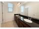 Bathroom features a double vanity with dark countertops and framed mirror with contemporary light fixture at 12615 Salomon Cove, Windermere, FL 34786