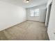 Bright bedroom with neutral carpet, white walls and natural light from the window and door at 12615 Salomon Cove, Windermere, FL 34786