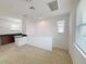 Bright living room features neutral walls, carpet, and an open layout to the kitchen and stairs at 12615 Salomon Cove, Windermere, FL 34786