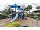 View of a blue playground with a slide, climbing structures, and shade canopies at 12615 Salomon Cove, Windermere, FL 34786