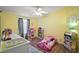 Cozy bedroom with bright yellow walls, ceiling fan, and hardwood floors at 13201 Plum Lake Cir, Minneola, FL 34715