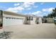 View of the attached garage and adjacent carport offering generous parking for this lovely home at 13201 Plum Lake Cir, Minneola, FL 34715