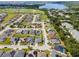 An aerial view showcasing a residential community with various homes, landscaping, and a lake in the distance at 133 Hillcrest Dr, Davenport, FL 33897