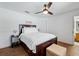 Cozy bedroom with dark wood bed frame, white bedding, and a rustic ceiling fan at 133 Hillcrest Dr, Davenport, FL 33897