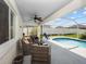 A covered patio features comfortable seating and a ceiling fan, adjacent to a screened pool area at 133 Hillcrest Dr, Davenport, FL 33897