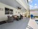 A covered patio offers a relaxing seating area, complete with a ceiling fan, next to a pool at 133 Hillcrest Dr, Davenport, FL 33897