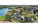 Aerial view of the lakefront home with circular driveway, lush landscaping, and city skyline in background at 1355 S Summerlin Ave, Orlando, FL 32806