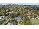 Aerial view of the beautifully landscaped home, framed by mature trees, with the city skyline in the distance at 1355 S Summerlin Ave, Orlando, FL 32806