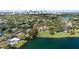 Expansive aerial view of lakefront home with pool, lush landscaping, and downtown skyline in background at 1355 S Summerlin Ave, Orlando, FL 32806