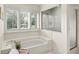 Well-lit bathroom with soaking tub, glass-enclosed shower and window with shutters at 1355 S Summerlin Ave, Orlando, FL 32806