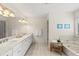 Bright bathroom featuring double vanity, soaking tub, and neutral tile at 1355 S Summerlin Ave, Orlando, FL 32806