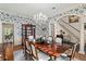 Dining room with floral wallpaper, hardwood floors, crystal chandelier, and view of entry staircase at 1355 S Summerlin Ave, Orlando, FL 32806