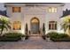 Elegant front entrance features manicured landscaping, a gray door, a circular driveway, and refined architecture at 1355 S Summerlin Ave, Orlando, FL 32806