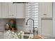 Close up of a kitchen sink with stainless steel hardware, light countertops and window at 1355 S Summerlin Ave, Orlando, FL 32806