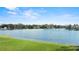 Picturesque view of the lake bordered by lush green lawn and mature trees under a blue sky at 1355 S Summerlin Ave, Orlando, FL 32806