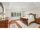 Bright bedroom features a tray ceiling, light walls, wood floors, and a large window with plantation shutters at 1355 S Summerlin Ave, Orlando, FL 32806