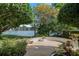 Outdoor patio with stone flooring overlooks the lake, surrounded by lush trees and landscaping at 1355 S Summerlin Ave, Orlando, FL 32806