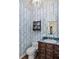 Charming powder room featuring floral wallpaper, dark wood vanity, and decorative mirror at 1355 S Summerlin Ave, Orlando, FL 32806