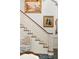 Elegant staircase with white balusters and a wooden handrail, adorned with paintings at 1355 S Summerlin Ave, Orlando, FL 32806