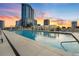 Rooftop pool with lounge chairs and cabanas, set against a colorful sunset and city skyline at 150 E Robinson St # 2602, Orlando, FL 32801