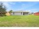 Expansive backyard view of the home with a well-maintained lawn and covered back porch at 16146 Sw 24Th Court Rd, Ocala, FL 34473