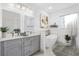 This bright bathroom features double sinks, quartz countertops, grey cabinets, and a soaking tub at 16146 Sw 24Th Court Rd, Ocala, FL 34473