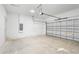 View of the two-car garage featuring concrete flooring, white brick walls, and a modern garage door at 16146 Sw 24Th Court Rd, Ocala, FL 34473