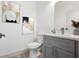 This charming powder room features a grey cabinet with a quartz countertop and tasteful artwork at 16146 Sw 24Th Court Rd, Ocala, FL 34473