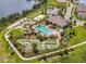 Aerial view featuring mini golf, a resort-style pool, clubhouse, sand volleyball, and a lake at 18417 Oliver Twist Way, Winter Garden, FL 34787