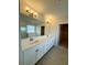 Bright bathroom features double sink vanity with white cabinets, quartz countertop and tile floor at 18417 Oliver Twist Way, Winter Garden, FL 34787