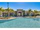 Gorgeous community pool with a beach entry and ample seating options surrounded by palm trees at 18417 Oliver Twist Way, Winter Garden, FL 34787